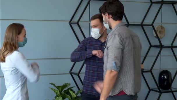 Współpracownicy biznesowi z maskami twarzy witający łokciami podczas pandemii koronawirusowej — Wideo stockowe