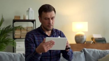 Kredi kartı tutan adam tablet bilgisayar ve ödemeyle online alım yapıyor. Bir adam banka kartını satın almak için kullanıyor..