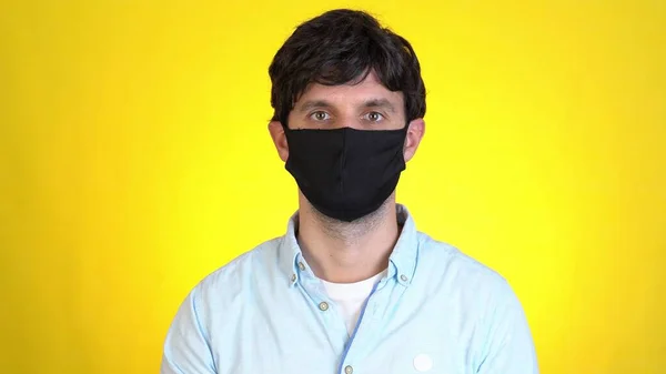 Hombre aislado en el estudio de fondo amarillo. Estilo de vida saludable enfermedad enferma tratamiento frío concepto de temporada. Señalando los dedos índice en la mascarilla que muestra los pulgares hacia arriba —  Fotos de Stock