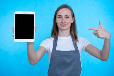 Boş tablet gösteren ve kameraya bakan mutlu bir kadının ön görüntüsü.