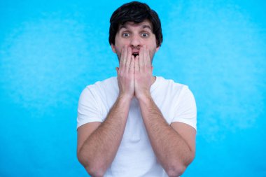 Mavi arka planda afallamış bir adamın portresi