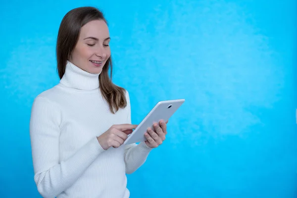 Feliz mujer de negocios utilizando tableta sobre fondo azul — Foto de Stock