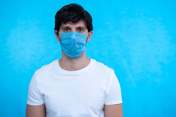 Homem retrato usando máscara médica em fundo azul. Proteja a sua saúde. Conceito de coronavírus — Fotografia de Stock