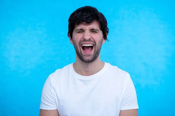 Primer plano retrato del hombre, chico está sorprendido, extremadamente feliz, con los ojos abiertos y la boca sobre fondo azul —  Fotos de Stock