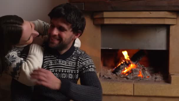 Junges romantisches Paar sitzt zu Hause vor dem Kamin — Stockvideo