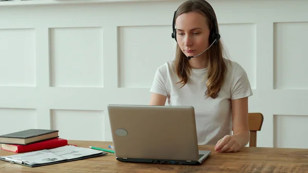 Operadora femenina que trabaja con auriculares y laptop en call center — Foto de Stock