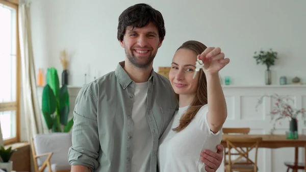 Young couple holds happily a key to their new home — Stock Photo, Image