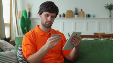 Erkeklerin elleri tablet tutuyor, bir adam tabletle bir odada oturuyor boş zamanlarını internette sohbet ederek, web sitelerini karıştırarak geçiriyor.