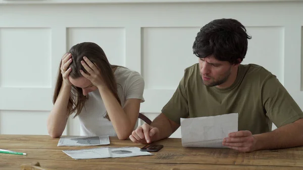 Casal jovem estressado calculando despesas domésticas mensais, pagamento de contas de cartão de crédito. — Fotografia de Stock