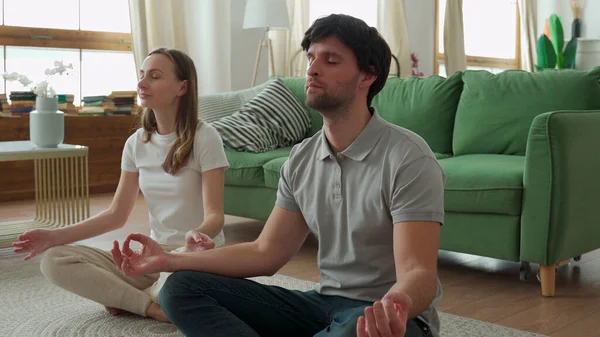 Pareja joven está haciendo entrenamiento de fitness en casa. Haciendo yoga juntos. concepto de estilo de vida saludable. — Foto de Stock