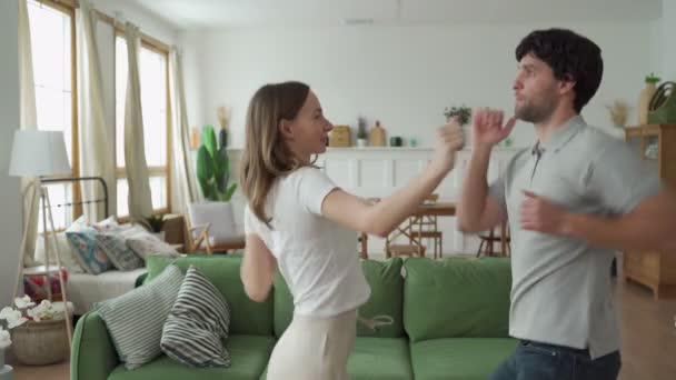 Romantiskt par hemma. Attraktiv ung kvinna och stilig man dansar hemma — Stockvideo