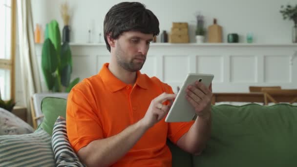 Homem feliz sentar relaxar no sofá sentir triunfo eufórico lendo boas notícias no tablet moderno — Vídeo de Stock