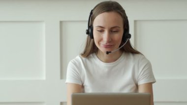 Çağrı merkezinde kulaklık ve dizüstü bilgisayarla çalışan kadın operatör