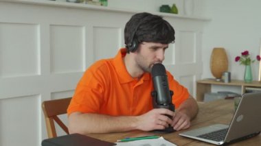 Stüdyoda mikrofonla konuşan bir adam internetteki blog için fikir beyan ediyor..
