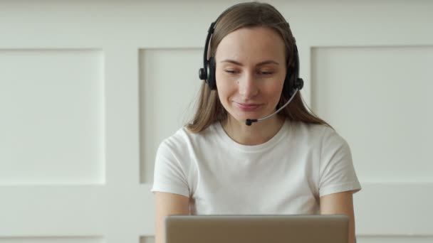 Operatrice che lavora con auricolari e laptop in call center — Video Stock