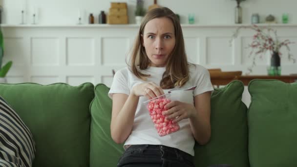 Mulher assistindo a um filme de terror e comer pipocas — Vídeo de Stock