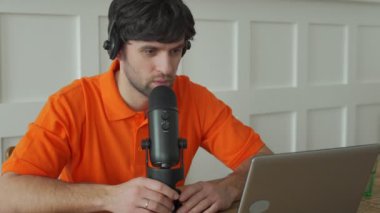 Stüdyoda mikrofonla konuşan bir adam internetteki blog için fikir beyan ediyor..
