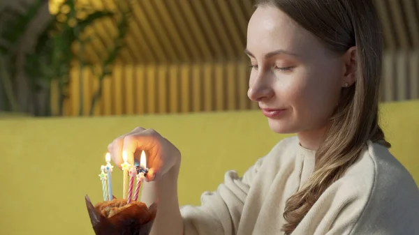 Woman lights a candle on a delicious cake — Stock Photo, Image