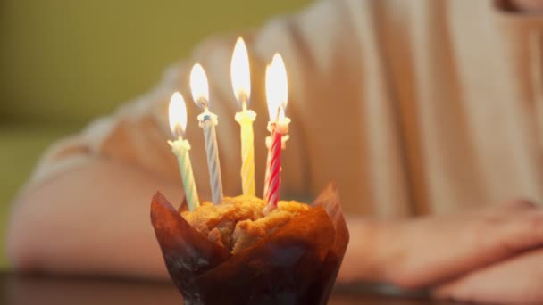 Close-up vrouw doet een wens, blaast de kaarsen uit op een verjaardagstaart en lacht — Stockvideo