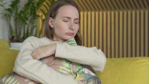 自宅で不幸な孤独な落ち込んでいる女性,彼女は黄色のソファに座っています — ストック動画