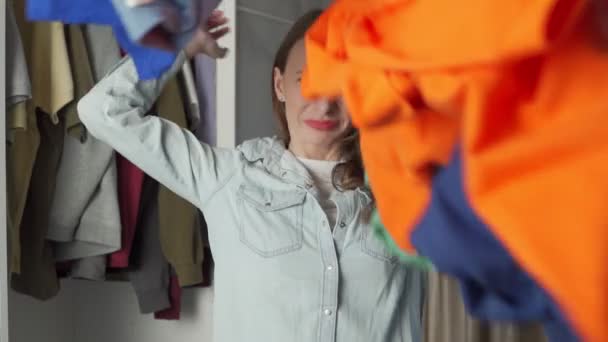 Een agressieve vrouw gooit haar vuile was in de lucht. Het concept van schoonmaak en wasserij. — Stockvideo