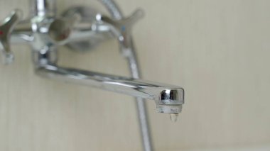 Su musluğu sızdırıyor. Musluktan su damlaları düşüyor.