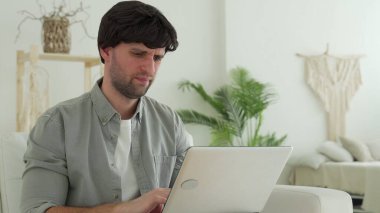 Genç adam dizüstü bilgisayarından çok kötü haberler alıyor. Başarısız olduğu için üzgün ve hayal kırıklığına uğramış.