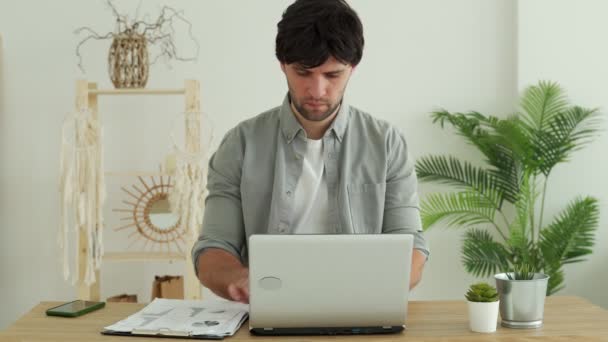 Az irodában dolgozó férfi laptopot használ az irodában. Fiatal profi ellenőrzi az e-maileket és leveleket küld. Irodavezető gépelés laptopon — Stock videók