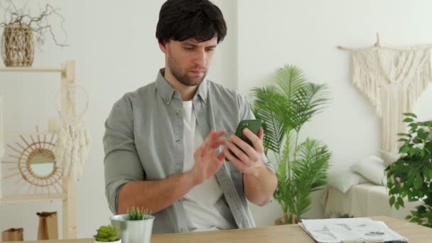 Homme d'affaires utilise un smartphone et souriant tout en travaillant dans le bureau — Video