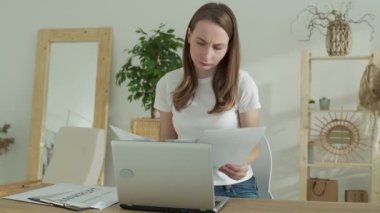 Çalışmaktan bıkmış stresli bir kadın, havaya kağıt döküman atıyor, çok çalışmaktan sıkılmış ve stresli hissediyor.