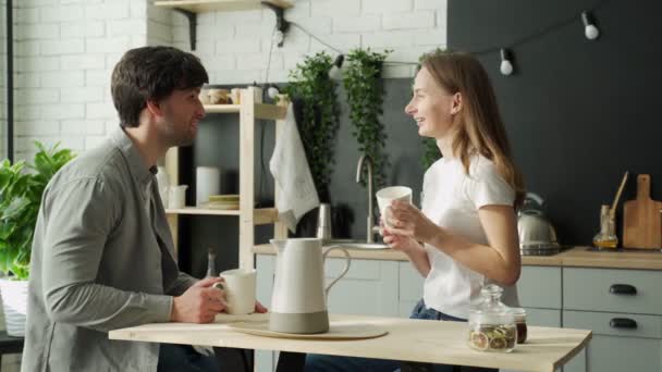 Pareja joven disfrutando de una pausa para tomar café juntos. Pareja sentada a la mesa, comiendo, hablando y riendo. — Vídeos de Stock