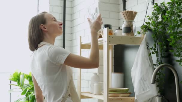 Hylde i køkkenet med kornprodukter i opbevaringsglas. Kvinde tager krukke pasta – Stock-video