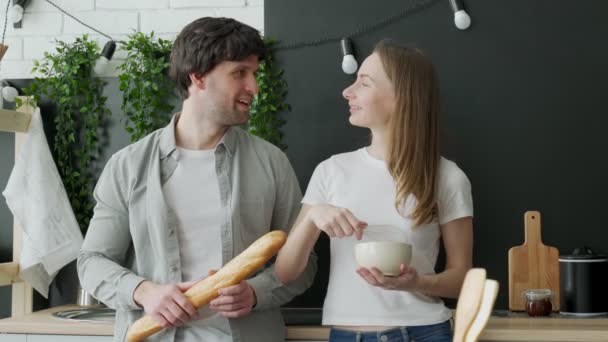 Romántica pareja joven cocinando juntos en la cocina, pasando un buen rato juntos — Vídeos de Stock