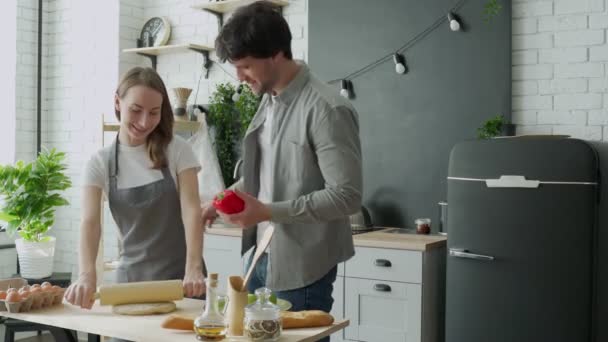 Jovem casal feliz está desfrutando e preparando refeição saudável em sua cozinha — Vídeo de Stock