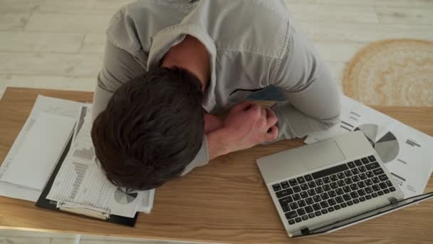 El hombre de negocios cansado se cansó de dormir sobre una computadora portátil en el escritorio. Joven cansado durmiendo en su oficina — Vídeo de stock