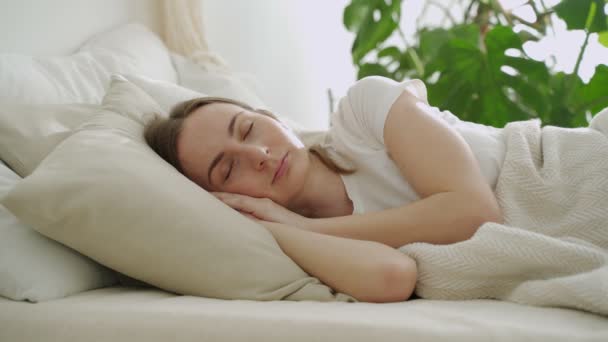 Junge Frau schläft auf weißen Kissen im Bett. Frau schläft friedlich im Bett — Stockvideo