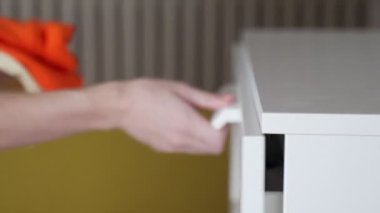 Kadınların elleri çekmecelerin içine giysi koyar. Eşyaların depolanmasında düzen kavramı