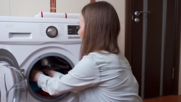 Mujer inhala el olor de una toalla limpia fresca después de lavarse en la lavadora — Vídeos de Stock