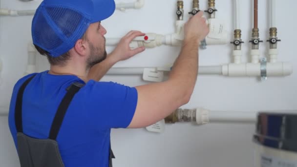 Uniformed plumber is at work - closing and opening the taps — Stock Video