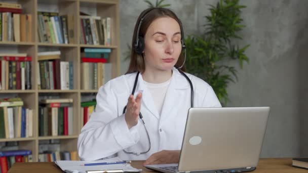 Woman doctor wear headset consult man patient make online webcam video call on laptop screen. — Stock Video