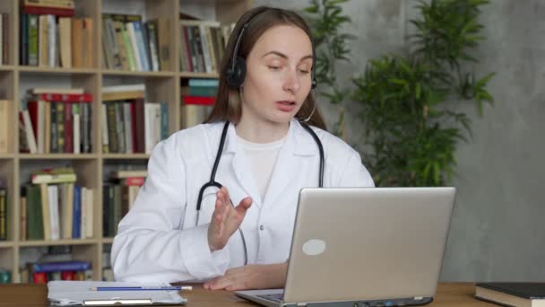 Woman doctor wear headset consult man patient make online webcam video call on laptop screen. — Stock Video