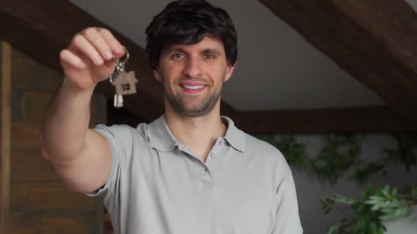 새 집 열쇠를 보여 주는 미소짓는 젊은 남자. — 비디오