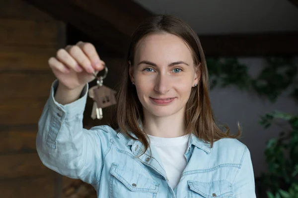 Портрет счастливой женщины, въезжающей с ключами от новой квартиры. Симпатичная женщина, стоящая в своем новом доме и показывающая ключи — стоковое фото