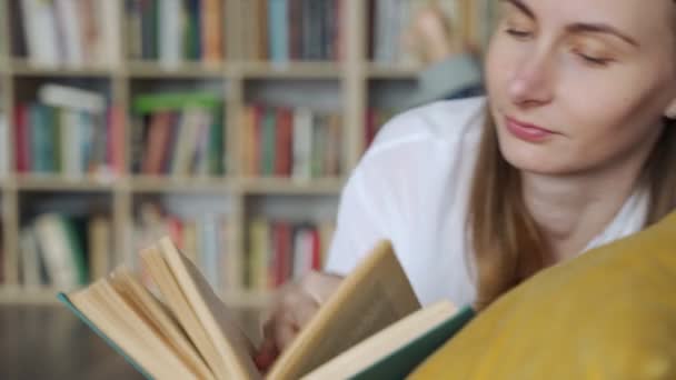 Gros plan femme couchée sur un canapé confortable et la lecture d'un livre passionnant — Video