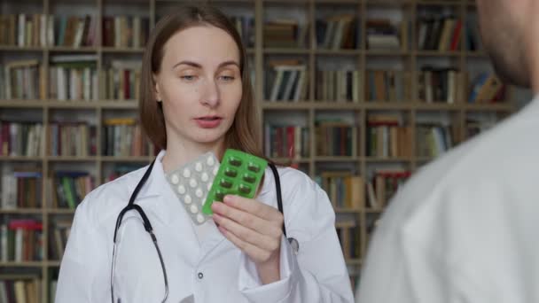 女性医師は診療所の男性患者に薬を与えます。医療、医療、保険の概念. — ストック動画