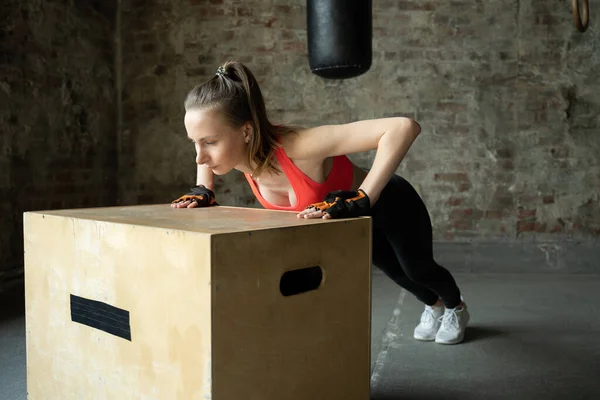 Мужчина, тренирующийся в спортзале, отжимается из деревянной коробки — стоковое фото