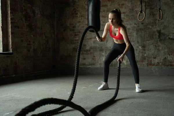 Woman with battle ropes exercise in the fitness gym. sportswoman working out with at gym — Stock Photo, Image