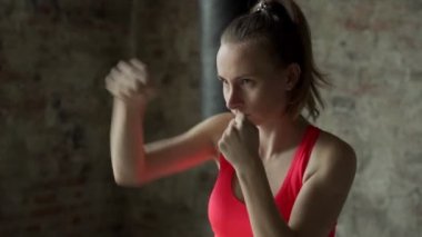 Ağır çekim atletik kadın yumruklarıyla havaya yumruk atıyor.