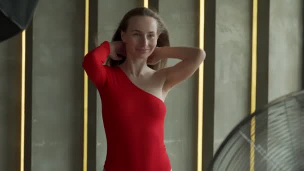 Mladá modelka žena s perfektním štíhlým tělem pózující v červeném obleku. Módní studio záběr. — Stock video