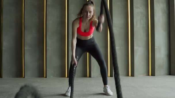 Mulher com cordas de batalha exercício no ginásio de fitness. esportista trabalhando fora com no ginásio — Vídeo de Stock